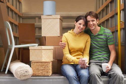 Trained mover carrying furniture carefully with protective gear