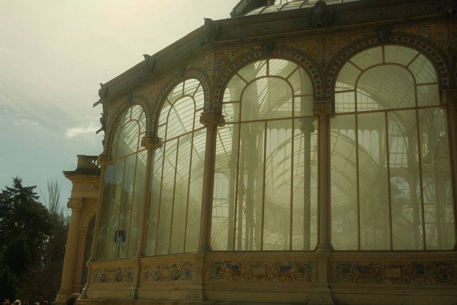 The image depicts the ornate glass-domed structure of the Crystal Palace, with multiple interconnected domes featuring arched glass panels supported by metal framework. The largest central dome is top